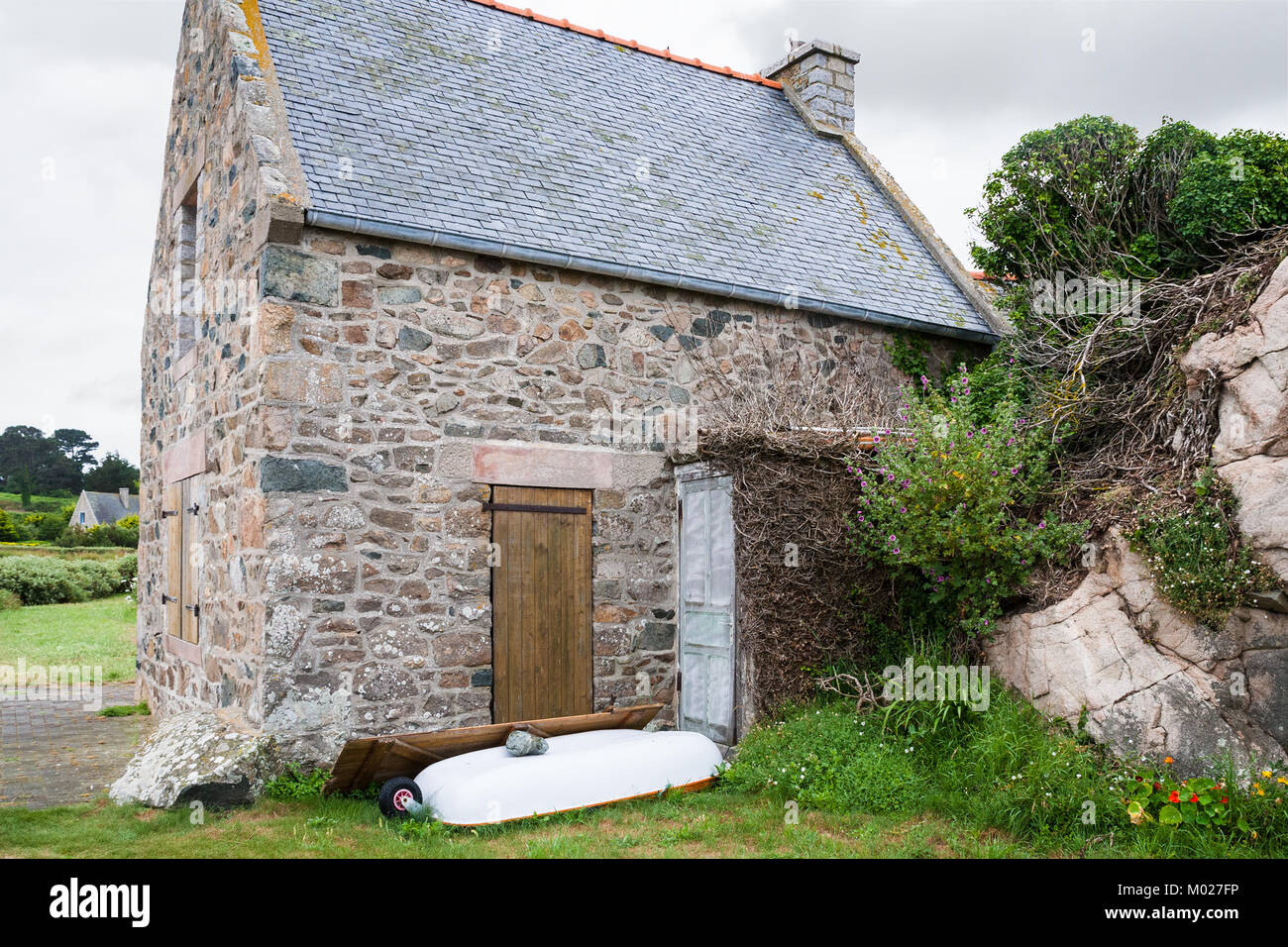 Voyage en France - maison bretonne en pierre typique de la ville de Plougrescant Côtes-d'Armor en Bretagne au jour d'été pluvieux Banque D'Images