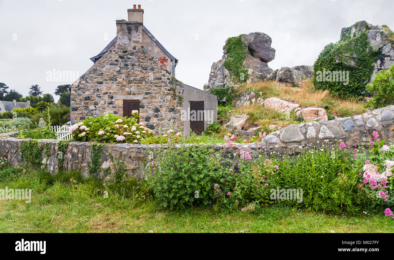 Voyage en France - maison bretonne typique en pierre avec jardin dans la ville de Plougrescant Côtes-d'Armor en Bretagne au jour d'été pluvieux Banque D'Images