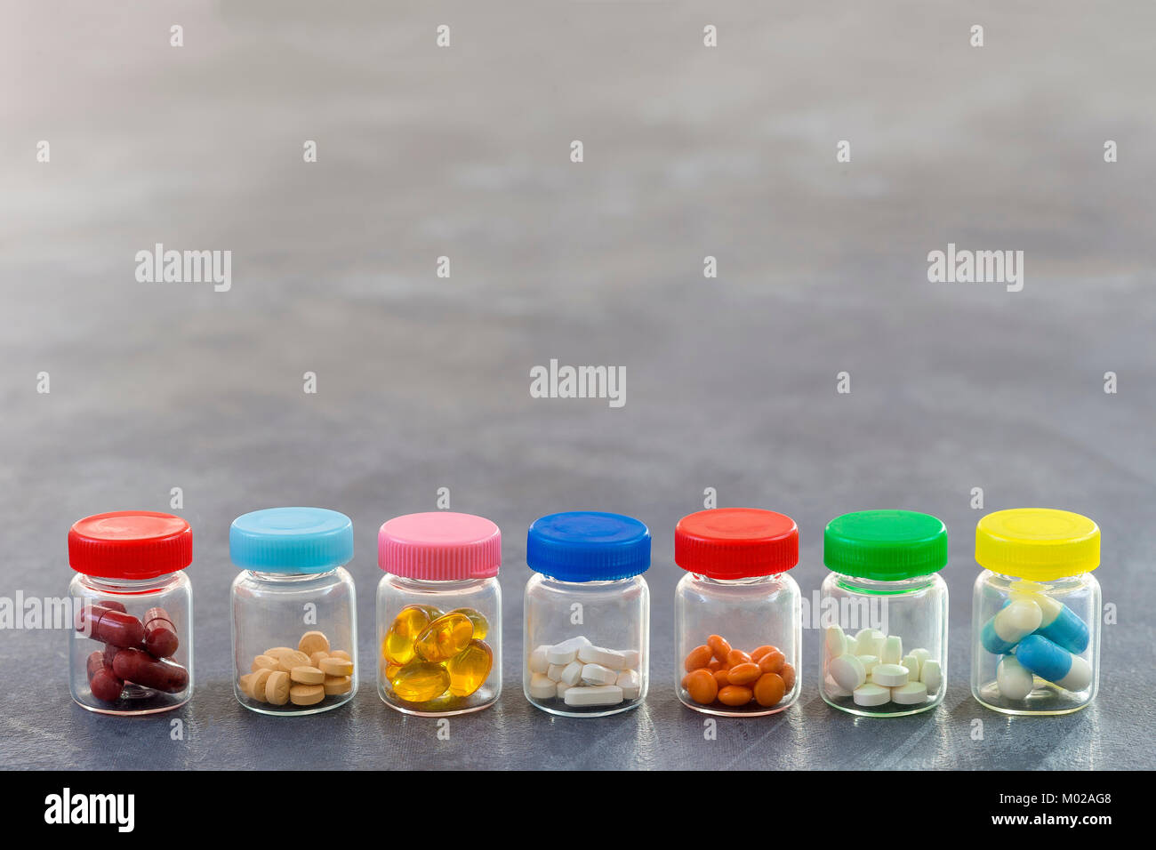 Medicine Concept : la ligne de médecine comprimés dans le flacon en verre avec bouchon en plastique de couleur sur fond d'ardoise Banque D'Images