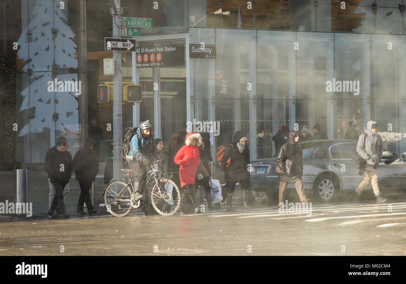 Les gens regroupés sur une froide journée d'hiver à Manhattan, attendre pour traverser la 6ème Avenue, sur la 42e Rue, de Bryant Park. Banque D'Images