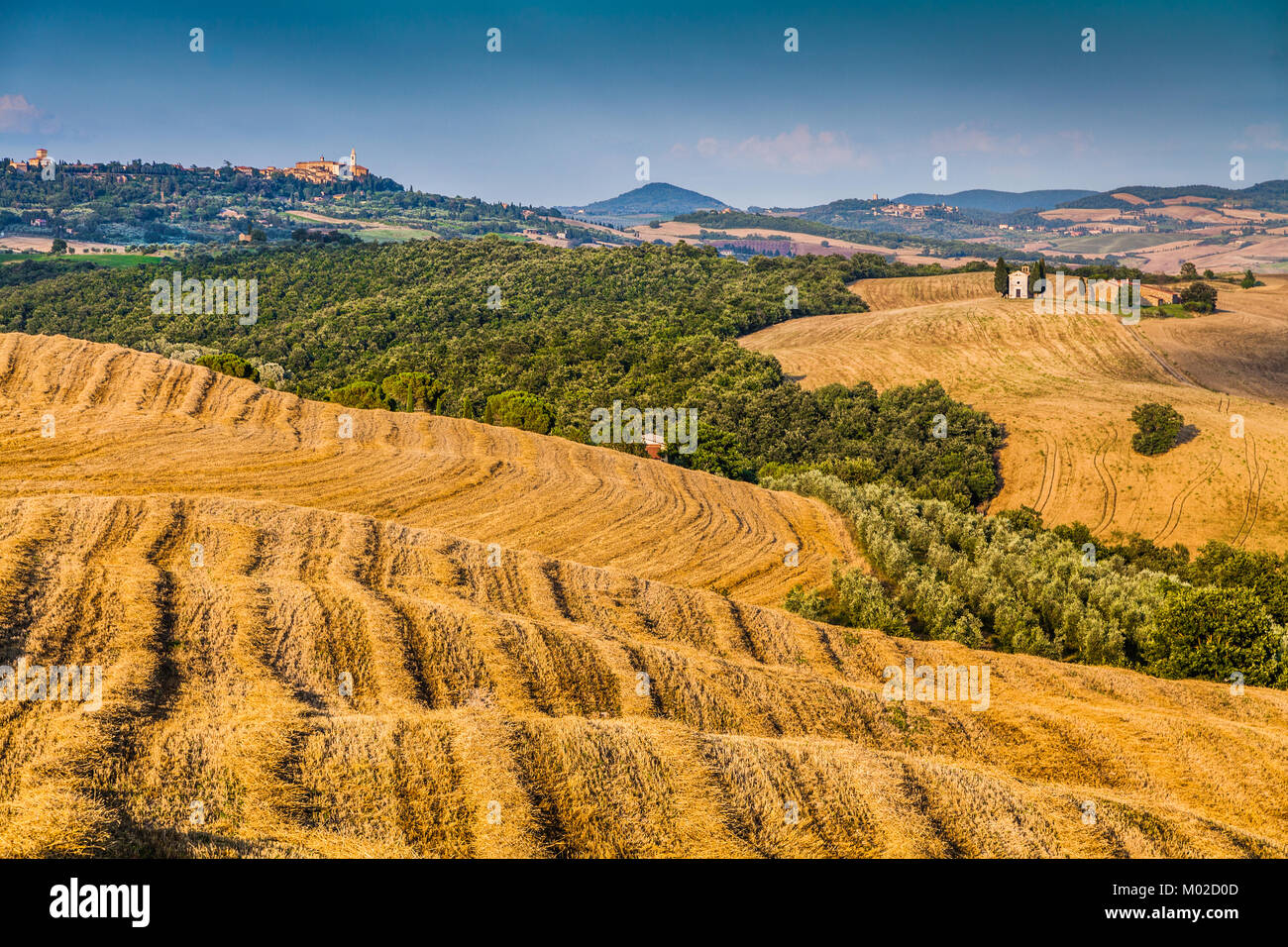 Collines et champs au coucher du soleil avec le célèbre Cappella della Madonna di Vitaleta et de la vieille ville de Pienza à l'arrière-plan en Toscane Banque D'Images