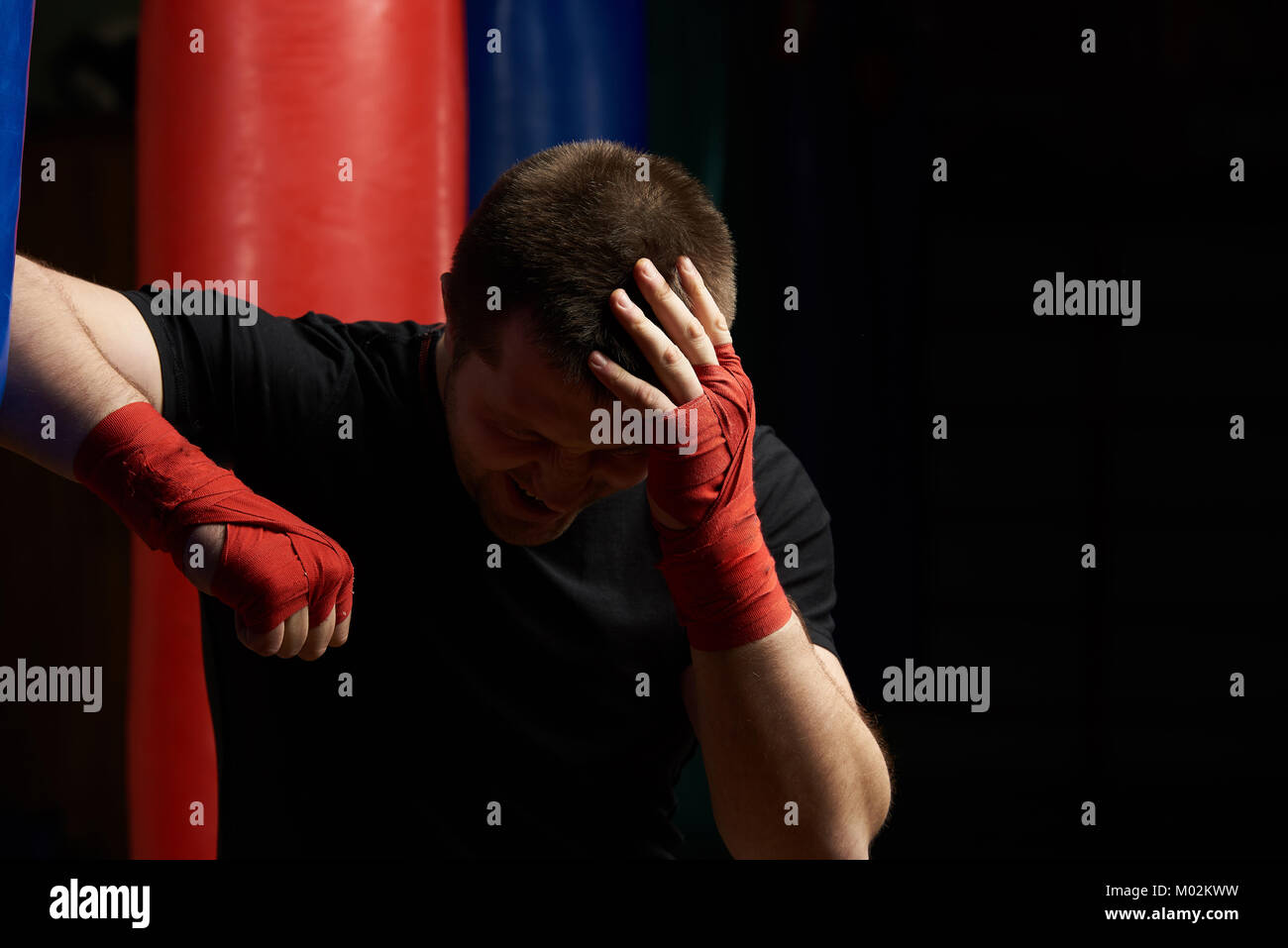 Boxing man holding head dans la douleur après une blessure. Thème des blessures à la tête Banque D'Images