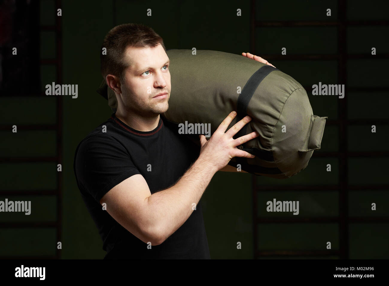 Portrait sport homme portrait. Homme portant un sac de sable sur l'épaule Banque D'Images