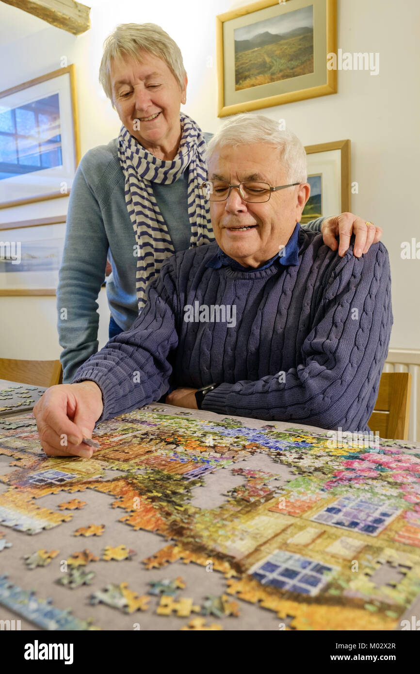 Vieux COUPLE TRAVAILLANT SUR UN PUZZLE UK Banque D'Images