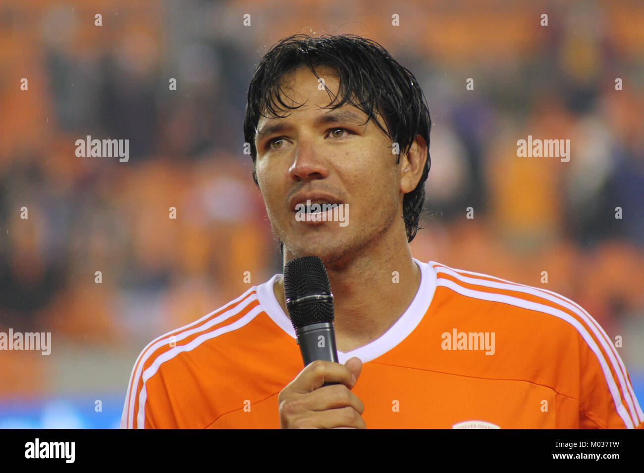 Brian Ching, un ancien joueur de soccer professionnel, est vu parler après un match de témoignage, commémorant probablement sa carrière. Cet événement reflète sa contribution au sport et son lien avec les fans et les coéquipiers. Banque D'Images