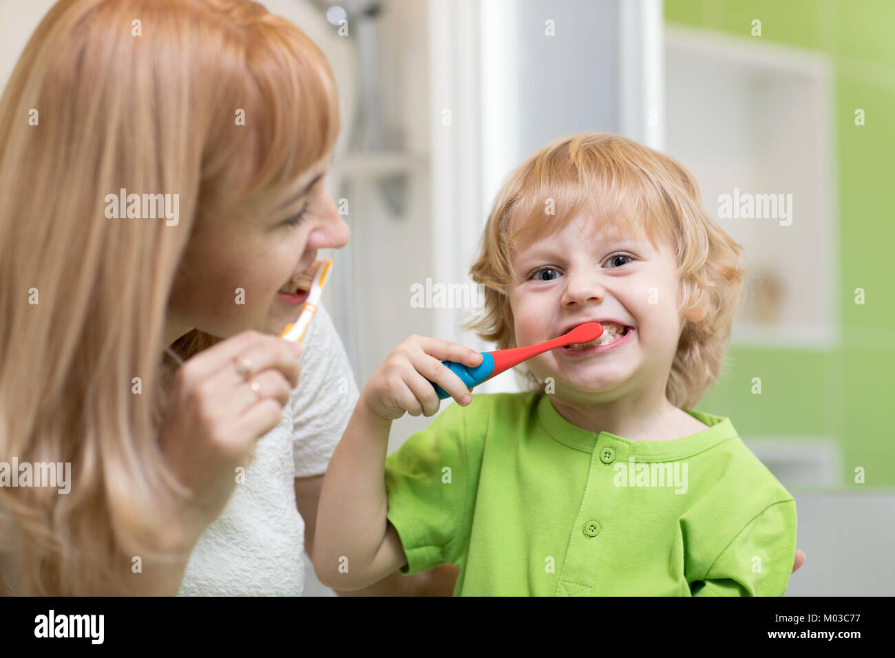 Mère de l'enfant apprend à ses fils comment brosser les dents Banque D'Images