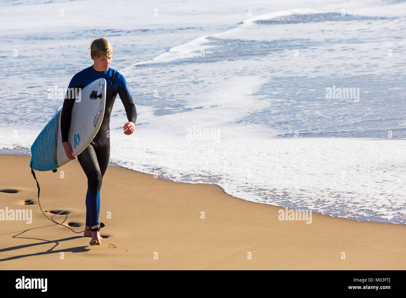 Surfer les promenades le long de la mer à la plage de Bournemouth, BOURNEMOUTH Dorset UK en Janvier Banque D'Images