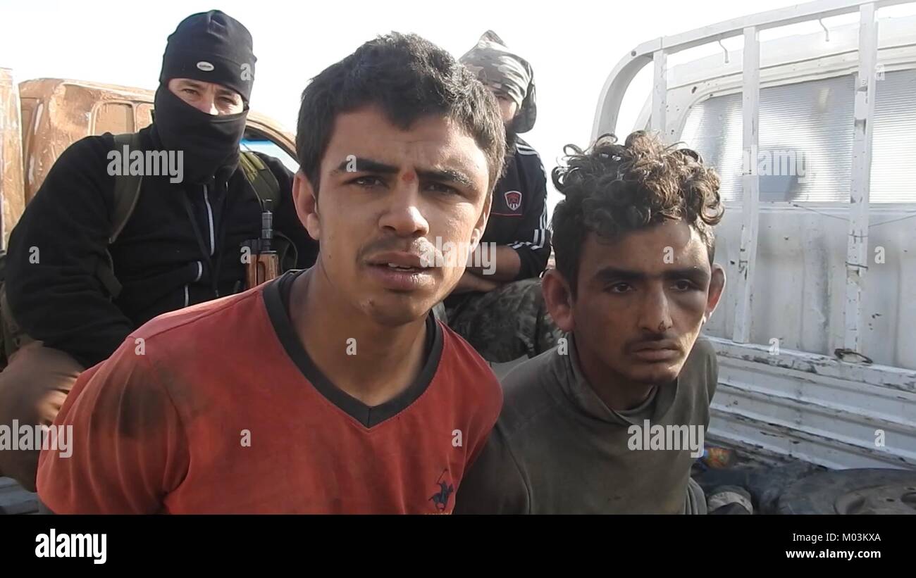 Toujours image réalisée à partir d'une vidéo de propagande publié le 14 janvier 2018 montrant des soldats de l'armée syrienne prisonniers d'État islamique près de combattants dans la base aérienne Abu Duhur Le Gouvernorat d'Idlib, en Syrie. Banque D'Images