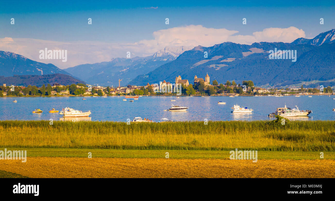 Belle vue des bateaux se trouvant dans le lac de Zurich avec la ville historique de Rapperswil à l'arrière-plan dans la lumière du soir au coucher du soleil d'or, Rapperswil-Jona Banque D'Images