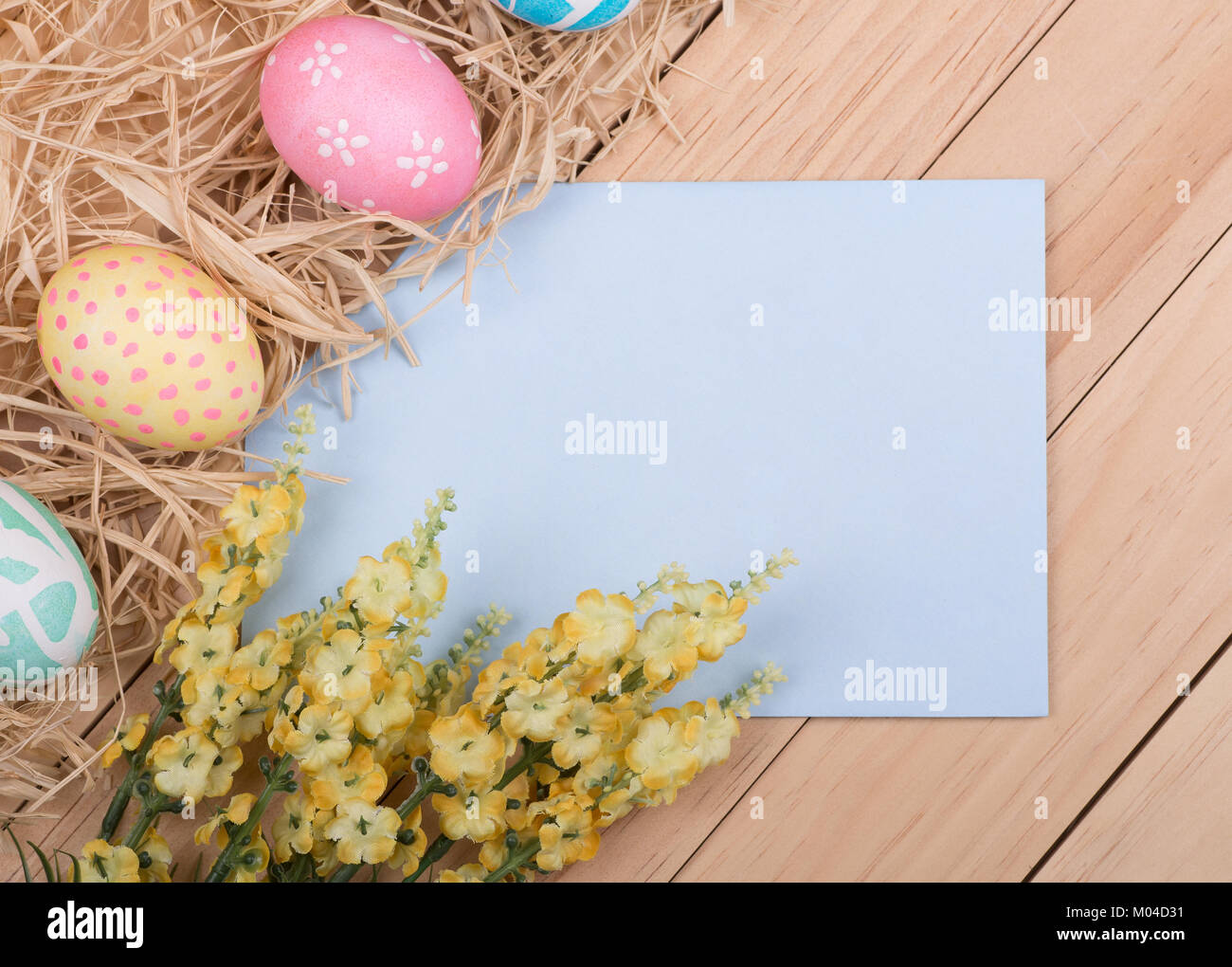 L'enveloppe vide entourée d'oeufs de Pâques décorés et des fleurs Photo  Stock - Alamy