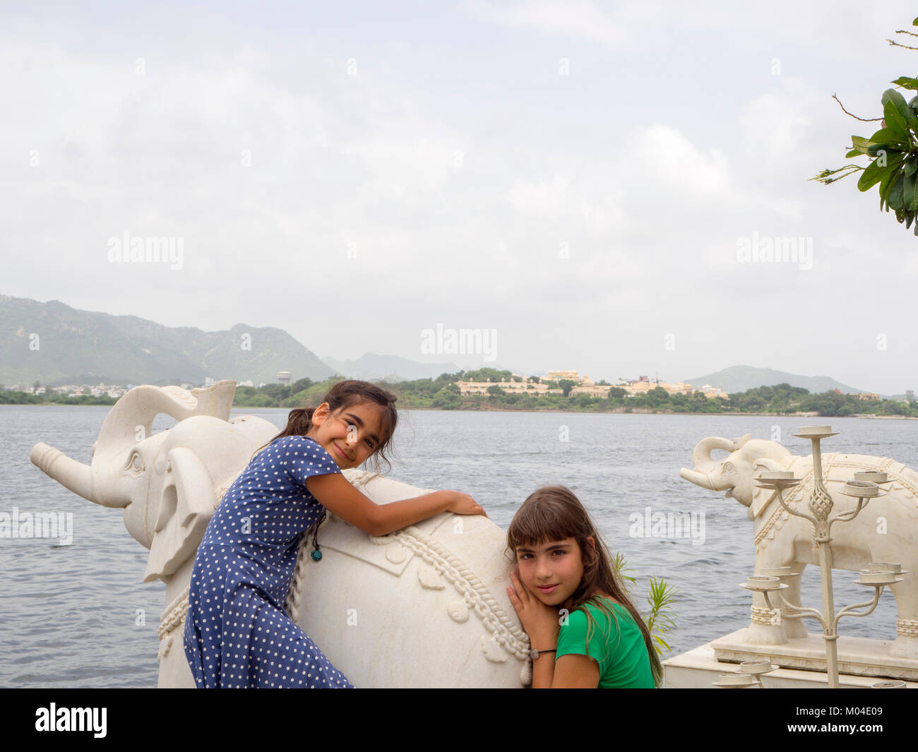 Une photo de deux belles filles soeur touristiques bénéficiant à un lac Indian Summer palace au Rajasthan Inde Banque D'Images