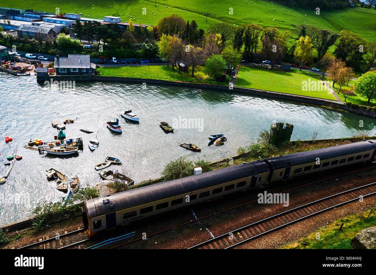 Bateau de pêcheur harbour village au Pays de Galles, Royaume-Uni, Angleterre ciel nuageux et Green Hills Banque D'Images
