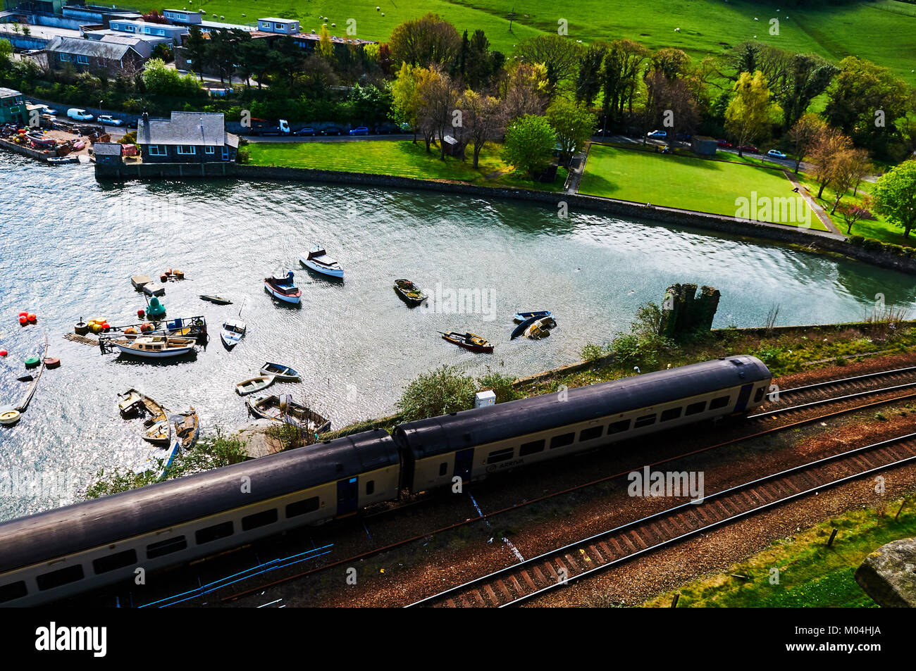 Bateau de pêcheur harbour village au Pays de Galles, Royaume-Uni, Angleterre ciel nuageux et Green Hills Banque D'Images