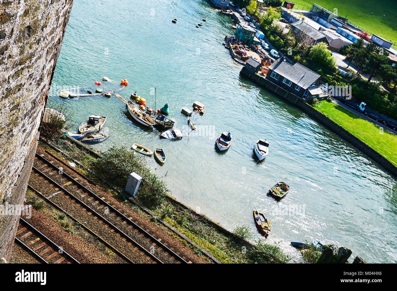 Bateau de pêcheur harbour village au Pays de Galles, Royaume-Uni, Angleterre ciel nuageux et Green Hills Banque D'Images