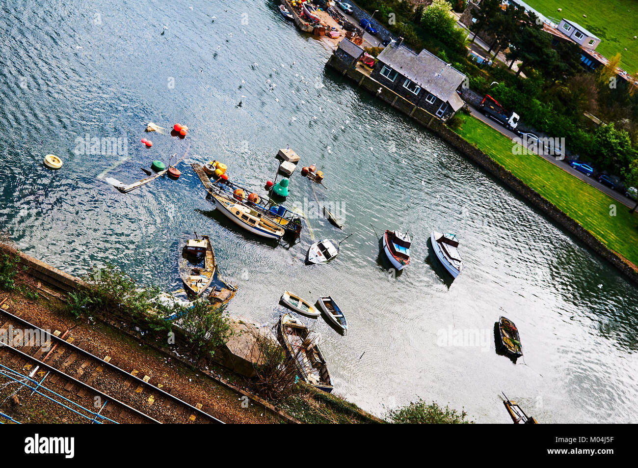 Bateau de pêcheur harbour village au Pays de Galles, Royaume-Uni, Angleterre ciel nuageux et Green Hills Banque D'Images