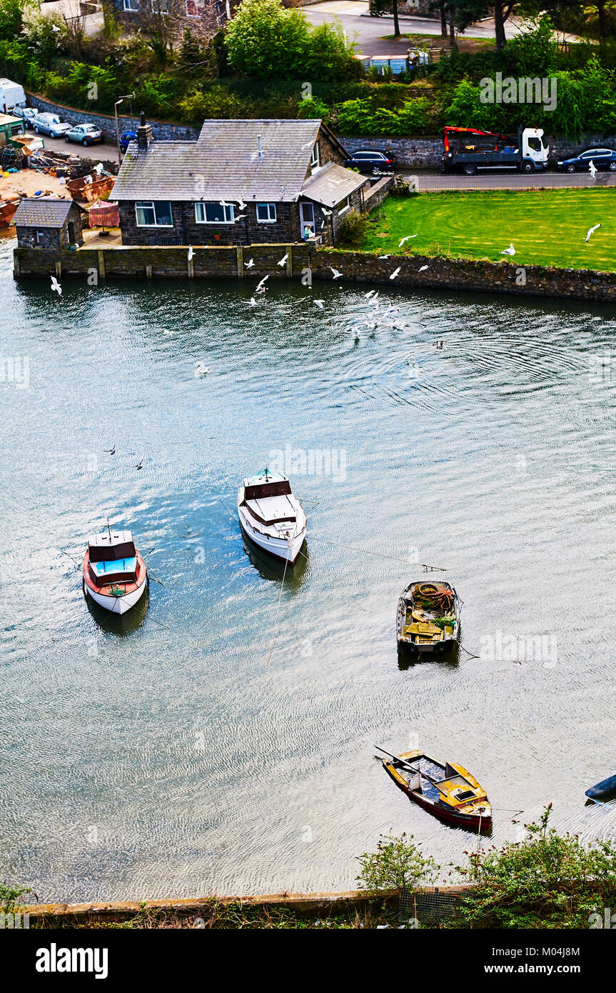 Bateau de pêcheur harbour village au Pays de Galles, Royaume-Uni, Angleterre ciel nuageux et Green Hills Banque D'Images