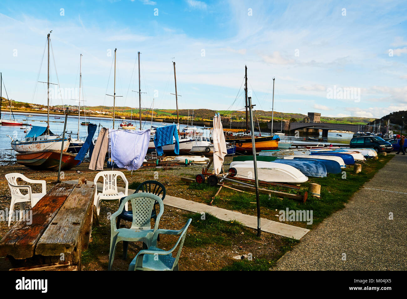 Bateau de pêcheur harbour village au Pays de Galles, Royaume-Uni, Angleterre ciel nuageux et Green Hills Banque D'Images