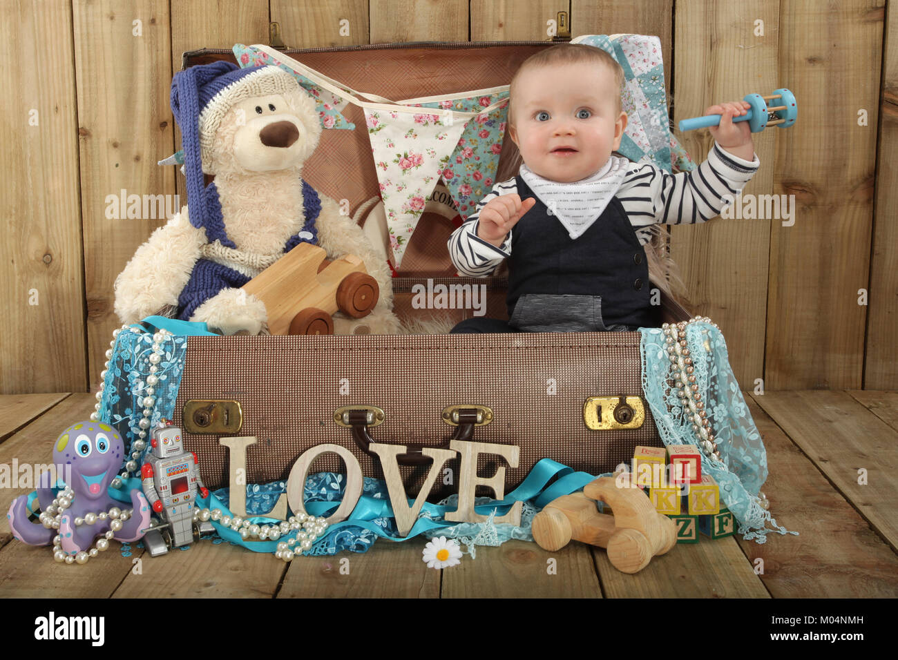 Un bébé de 9 mois Garçon jouant dans suitcase avec teddy Banque D'Images