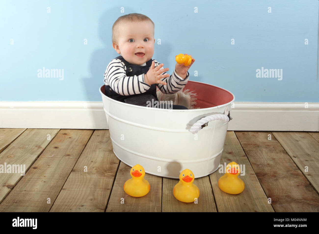 Un bébé de 9 mois Garçon jouant avec des canards en caoutchouc Banque D'Images