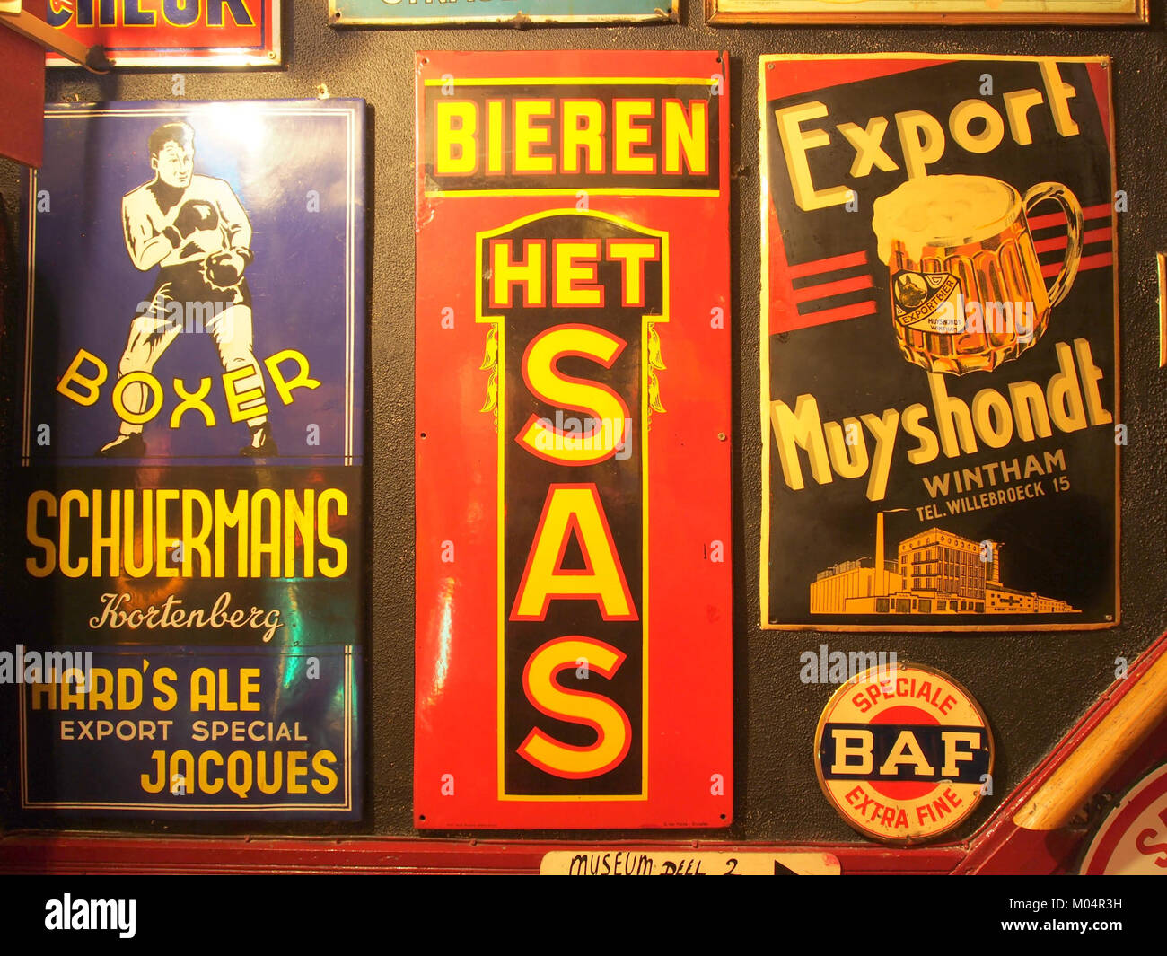 Il s'agit d'un ensemble de panneaux publicitaires en émail faisant la promotion de diverses boissons, dont Boxer Schuermans Hards Ale, Het SAS Bieren et Export Muyshondt. Ces enseignes vintage reflètent l'utilisation historique de l'émail pour le marketing commercial. Banque D'Images