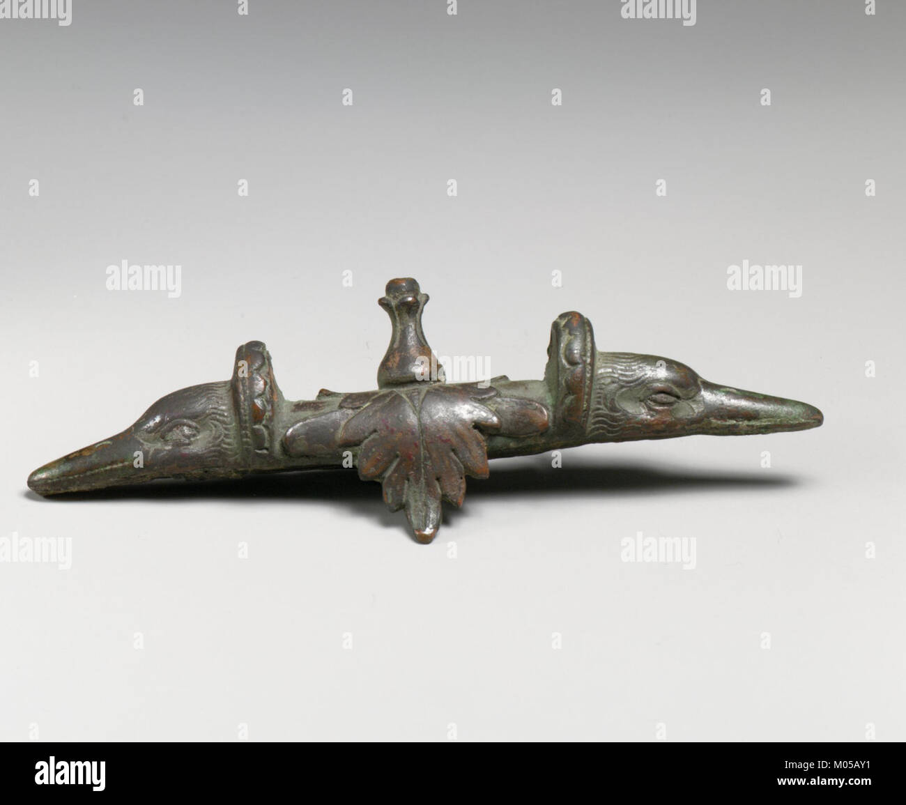 La poignée Bronze Attachment with Duck Heads est un artefact décoratif logé dans la collection MET. La pièce présente un savoir-faire détaillé en bronze, éventuellement utilisé dans le cadre d'un objet plus grand, mettant en valeur l'habileté des anciens métallurgistes dans la création d'objets fonctionnels mais ornementaux. Banque D'Images