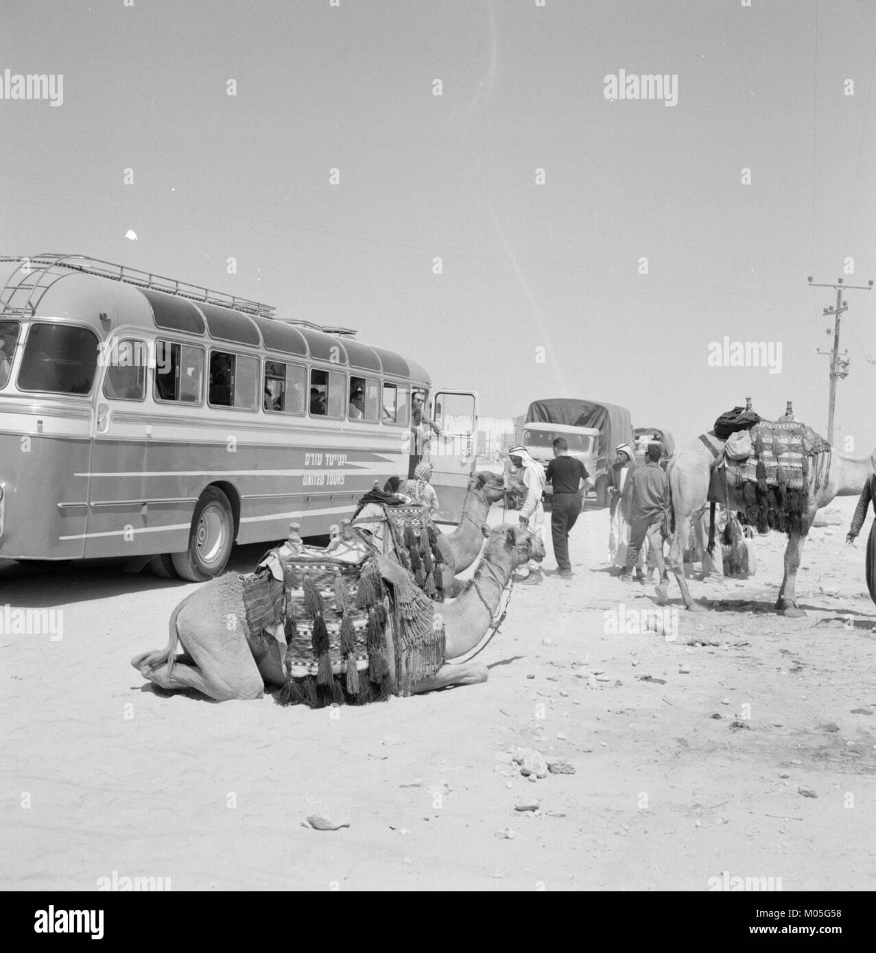 Un bus avec des touristes s'est arrêté dans le désert près de Beersheba, Israël, permettant aux passagers de débarquer et d'explorer les environs. Cette scène capture un moment dans le paysage désertique, soulignant la beauté aride de la région. Banque D'Images