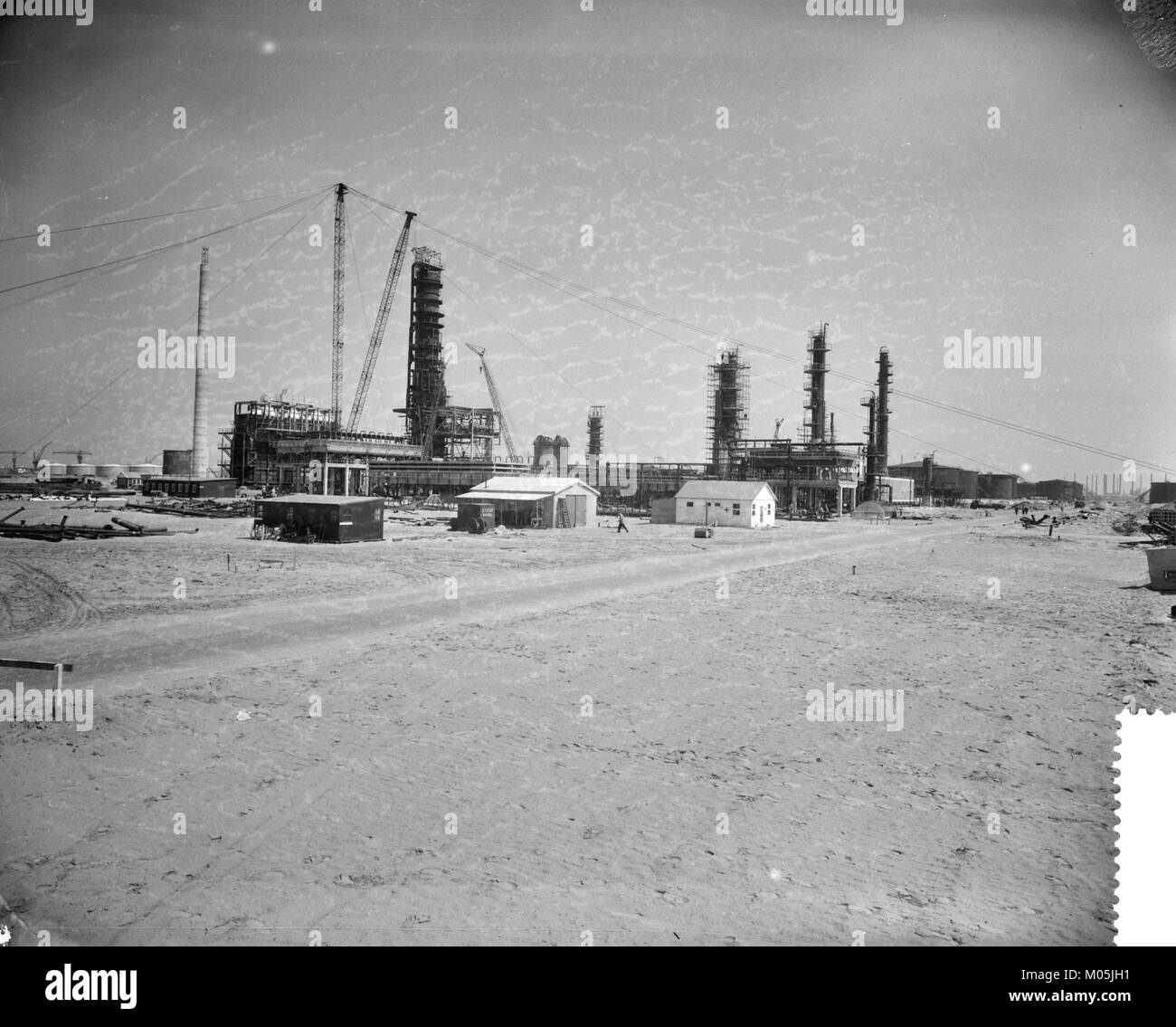 Cette image montre la construction d'une raffinerie Esso dans la région de Botlek près de Rotterdam. Le projet, important dans l'industrie pétrolière et énergétique, représente le développement de l'infrastructure industrielle dans la région. Banque D'Images
