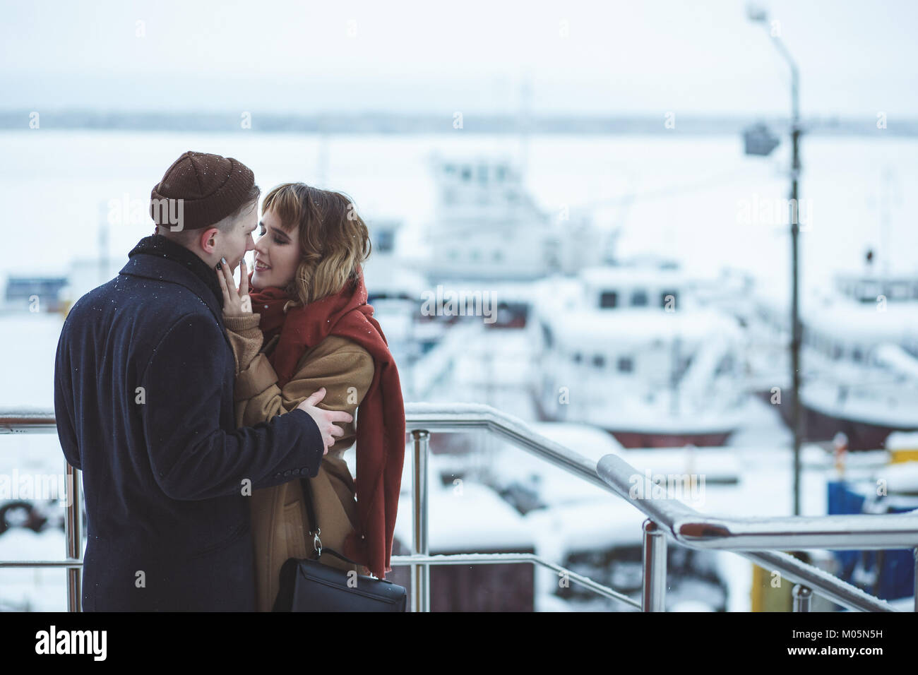 Couple au pont d'observation en ville d'hiver. Navires gelés dans bokeh Banque D'Images