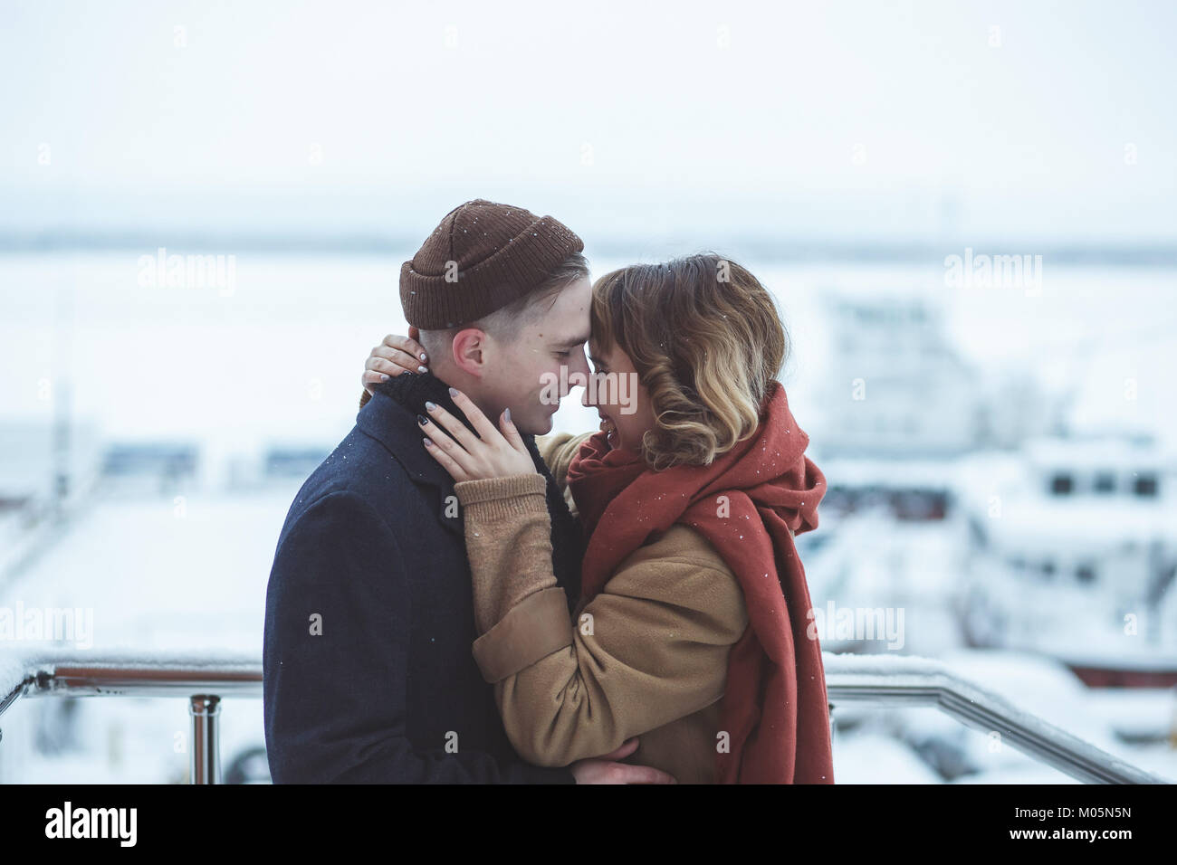 Couple au pont d'observation en ville d'hiver. Navires gelés dans bokeh Banque D'Images