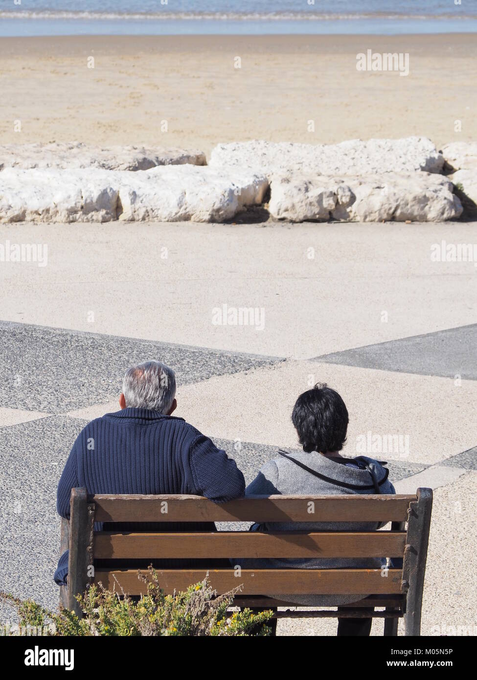 Un couple sur la plage de sable sur une parfaite journée claire et regarder la mer Banque D'Images