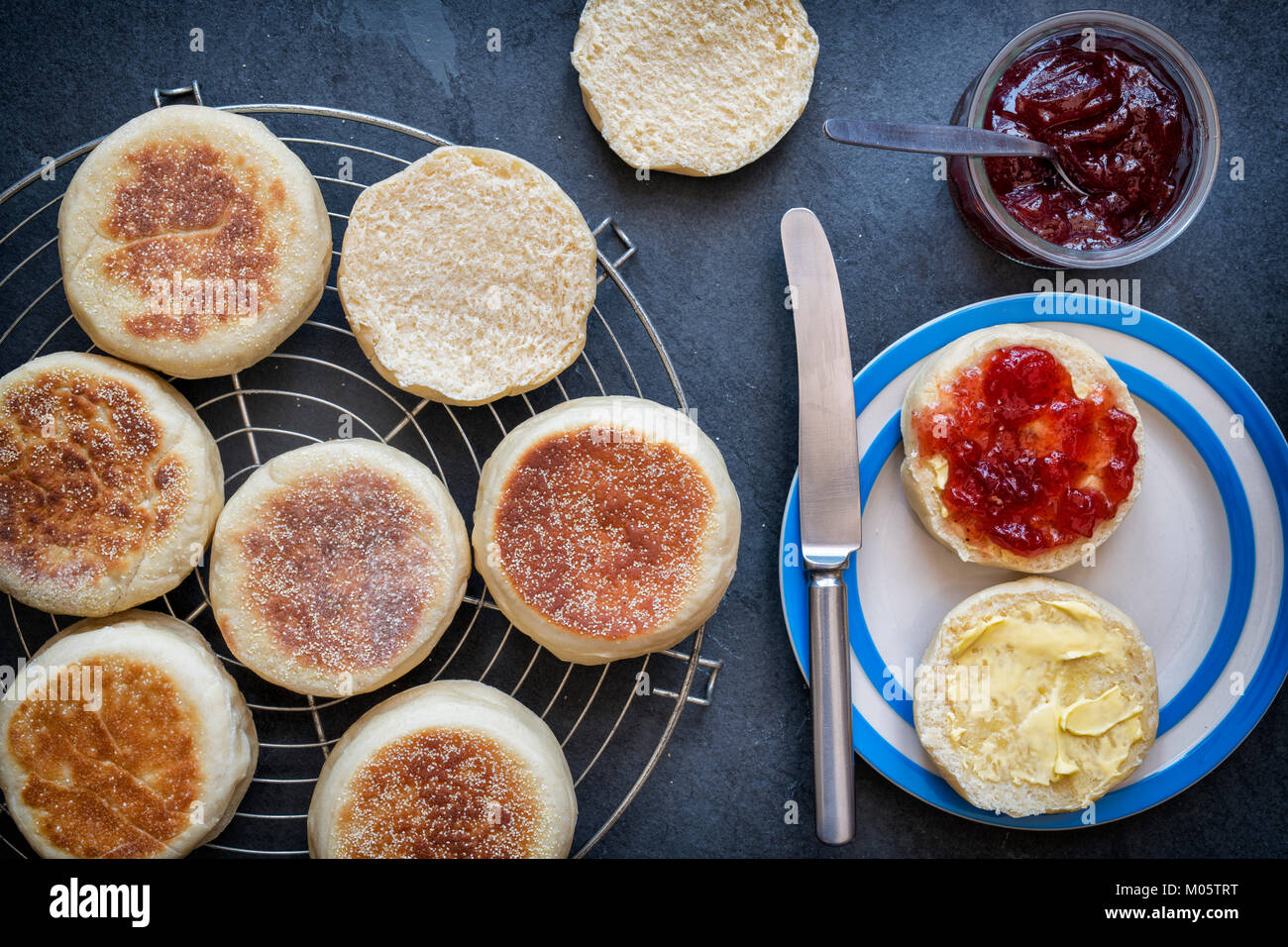 Muffins anglais avec de la confiture de fraise sur un fond d'ardoise Banque D'Images