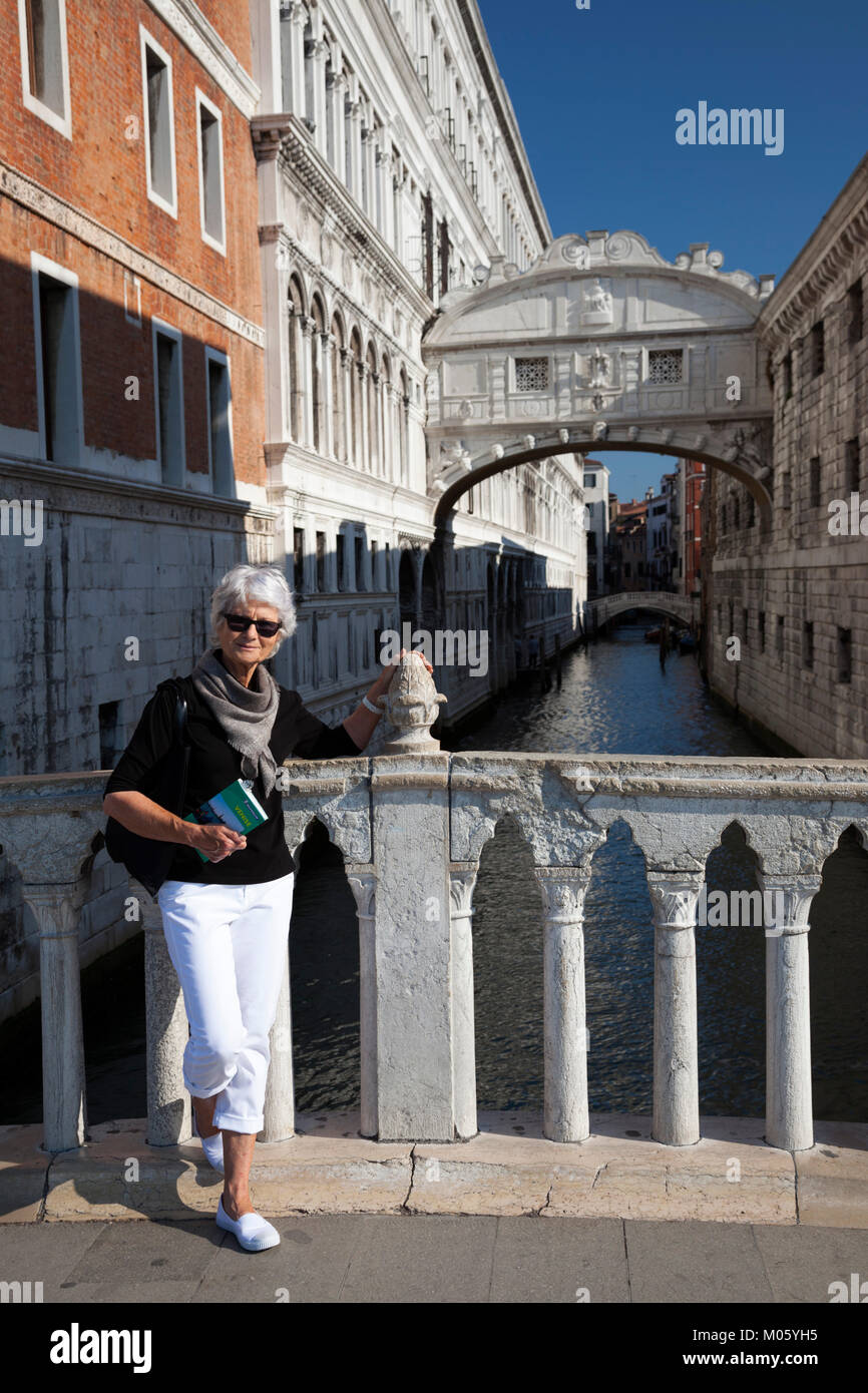 Équipé de son livre guide Michelin, un haut'posant devant le pont des soupirs à Venise (Italie). Banque D'Images