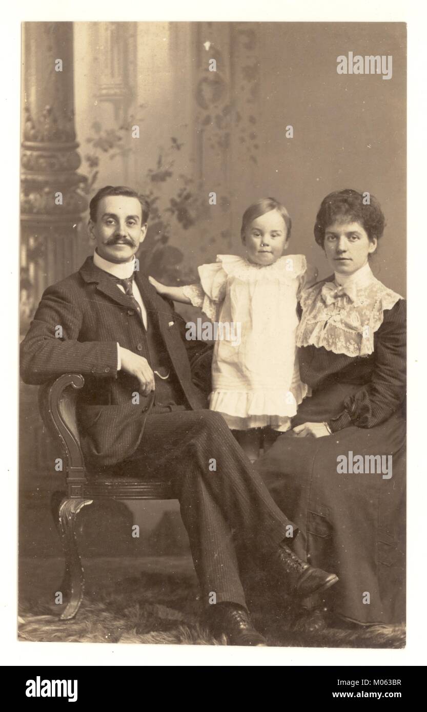 Studio de style édouardien carte postale de couple et l'enfant, les femmes portant une blouse avec col haut, l'homme a une impressionnante moustache, vers 1905, au Royaume-Uni. Banque D'Images