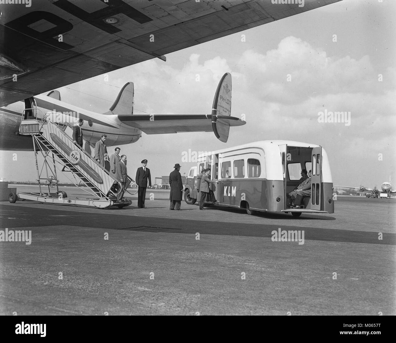 Busvervoer KLM van vliegtuig naar ontvangsthal, Bestanddeelnr 907-7034.jpg représente un bus KLM transportant des passagers d'un avion au terminal, illustrant les opérations de service au sol de la compagnie aérienne. Ce service facilite le transfert efficace entre l'avion et le terminal, améliorant ainsi le confort des passagers pendant les escales et les vols de correspondance. Banque D'Images