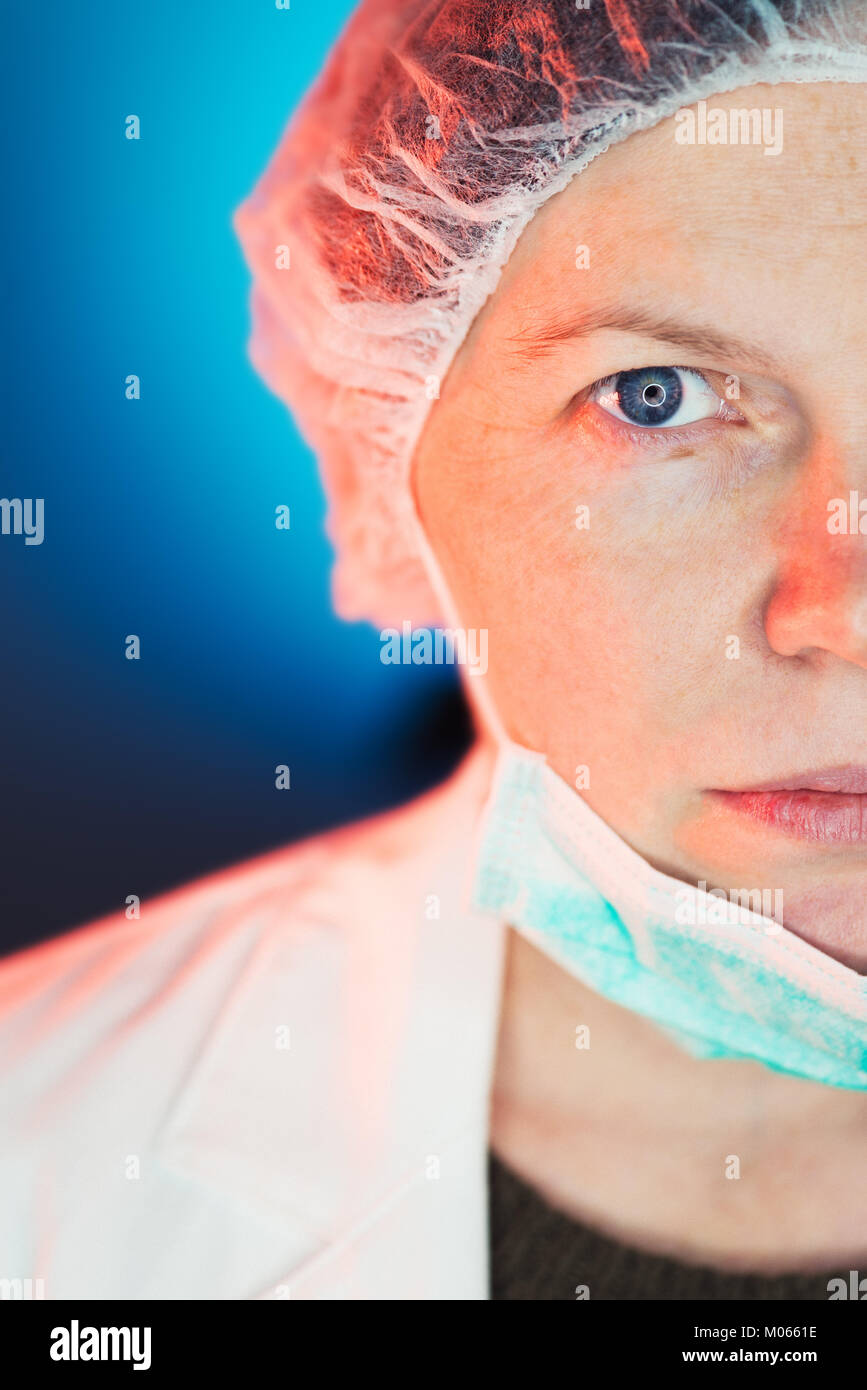 Immunologiste allergologue femelle la moitié face portrait, professionnel de la santé le port de masque de protection Banque D'Images