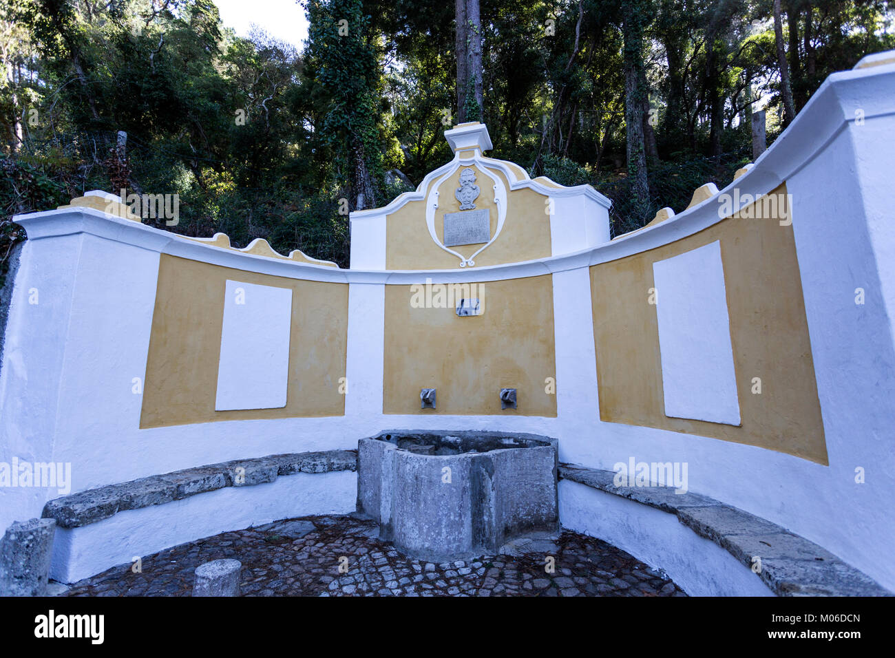 Le roi Fontaine a une forme semi-circulaire, un réservoir d'eau avec bancs et deux buses. Sur le dessus est un blason et un plateau avec un vieux portugais langag Banque D'Images