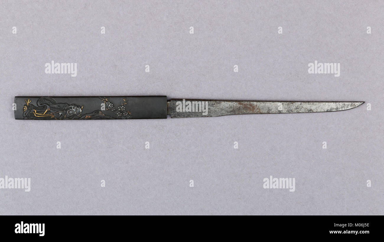 Un manche de couteau, faisant partie d'un kozuka avec lame, est un élément décoratif souvent trouvé dans les armes japonaises. Le savoir-faire met en évidence la compétence en métallurgie et design typique de l'époque. Banque D'Images