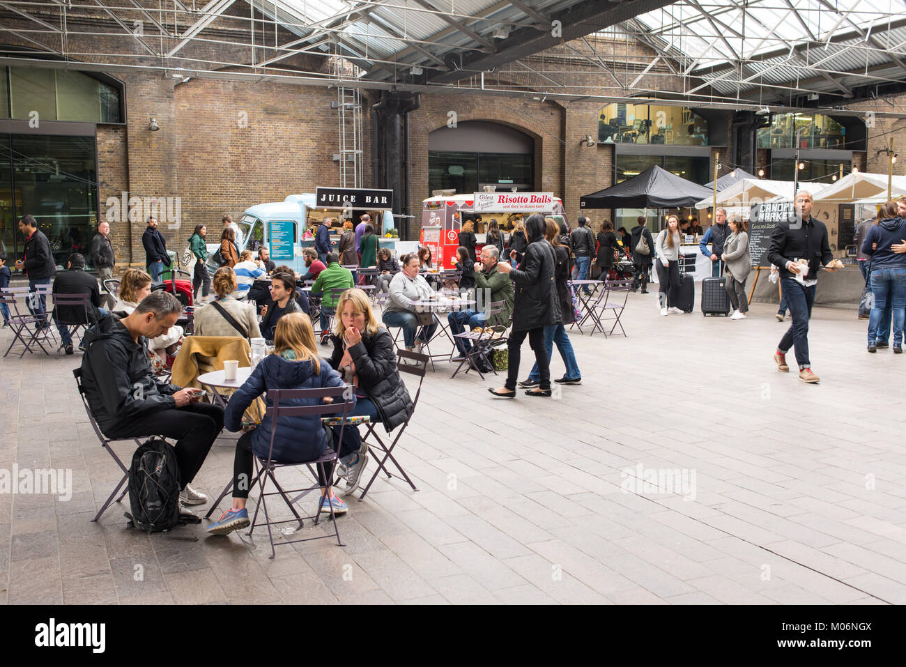 Les personnes mangeant et assis dans la zone de l'auvent inddor Market, King's Cross, Londres. Marché couvert est un marché près de la place du grenier à va Banque D'Images