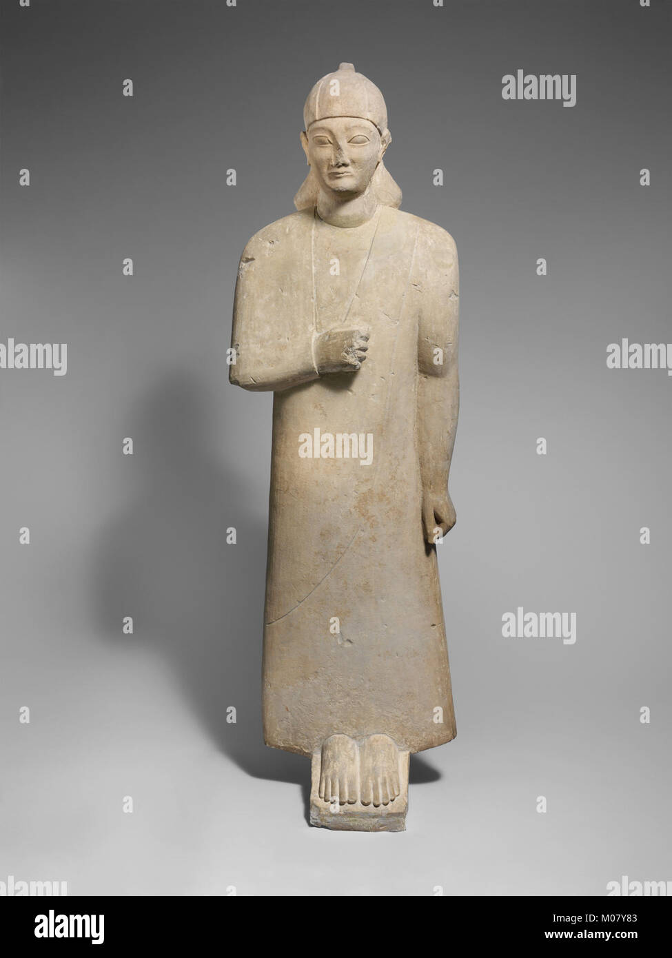 Votary calcaire d'un homme imberbe portant un long vêtement et d'un casque conique rencontré DP216660 Banque D'Images