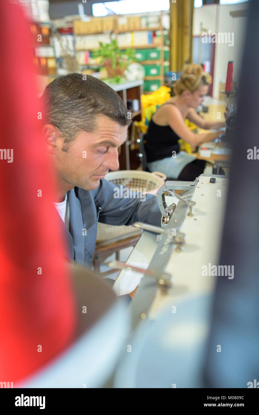 L'homme au travail à l'aide de la machine à coudre Banque D'Images