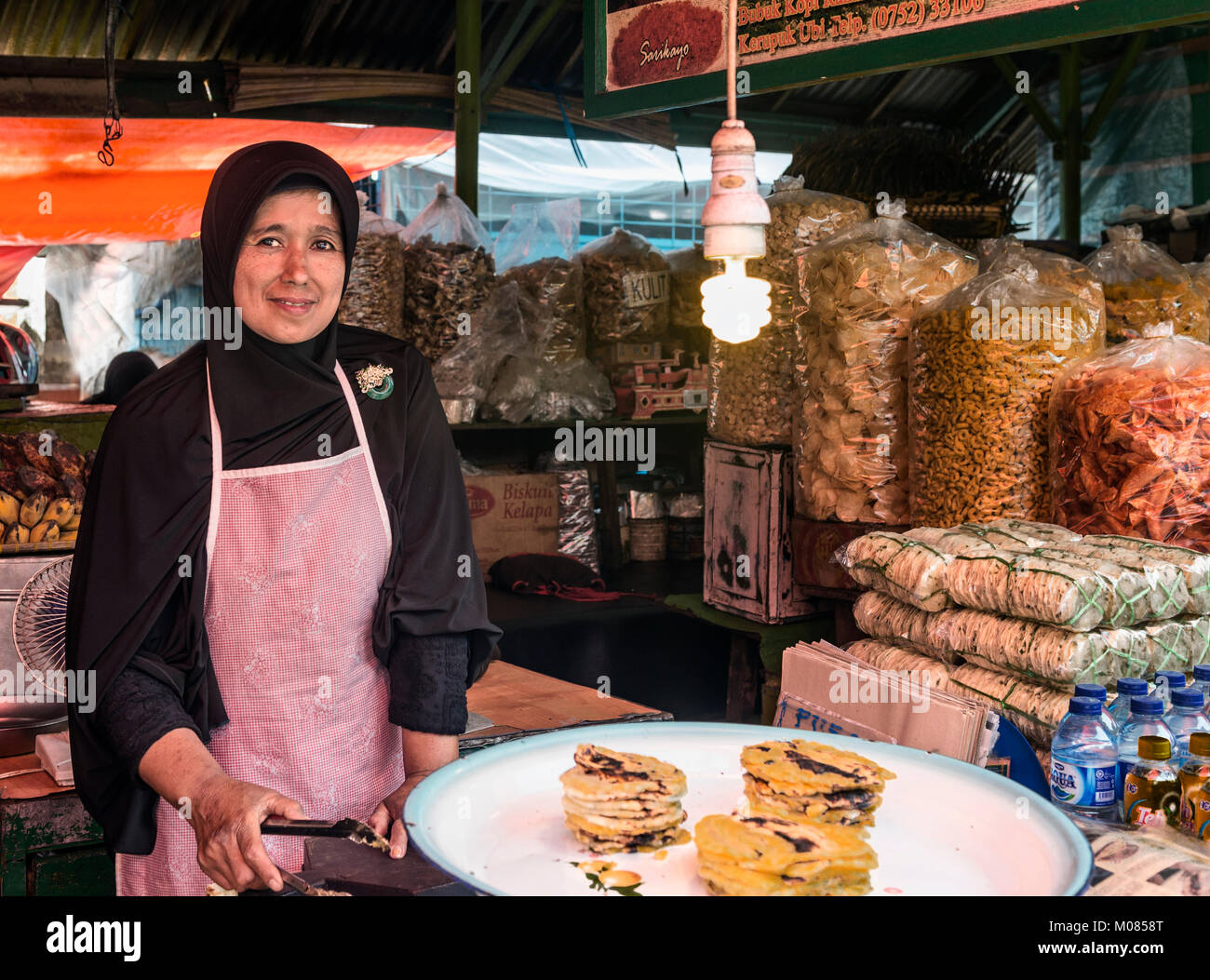 Femme travaillant dans un food à l'intérieur d'un petit marché, Sumatra, Indonésie Banque D'Images