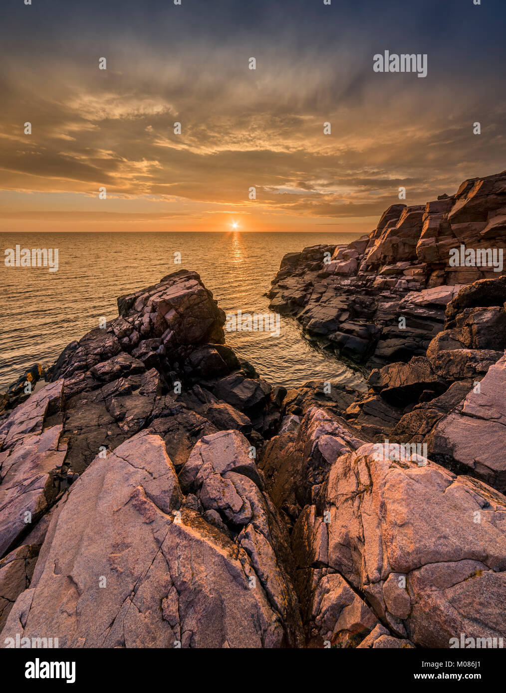 Coucher de soleil sur la mer et les rochers à la plage de Hovs Hallar réserve naturelle sur la péninsule de Bjare, Bastad, Skane, Suède, Scandinavie. Banque D'Images