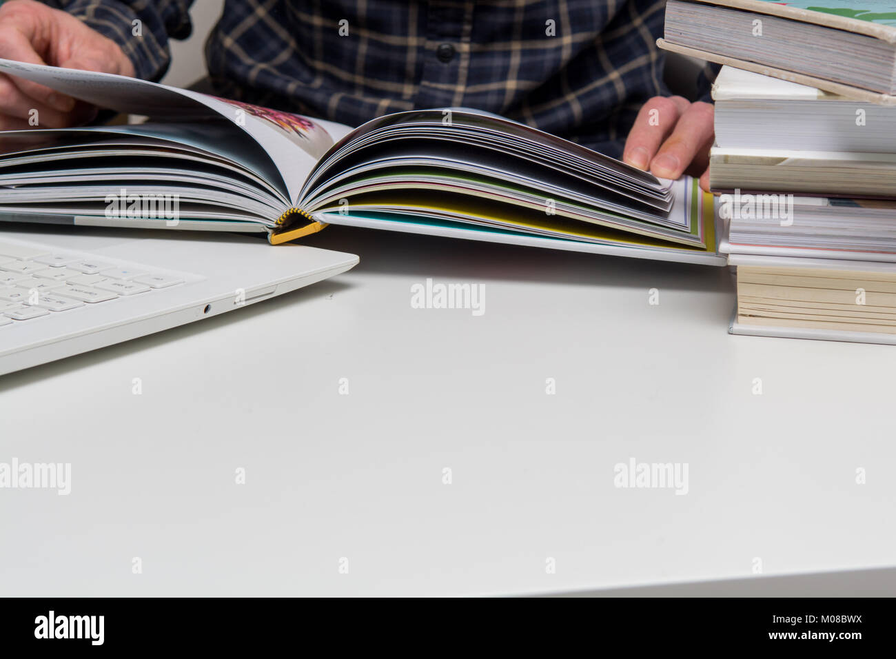 L'étude de l'homme et de la lecture des livres à un bureau blanc 24. L'apprentissage et la lecture des livres éducatifs pour faire de la recherche Banque D'Images