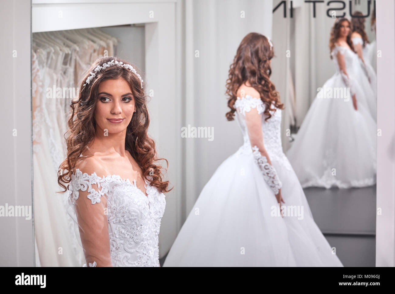 Une jeune mariée, à la recherche d'autonomie, le port d'une blouse, en image miroir arrière, vue avant, bridal salon. Banque D'Images