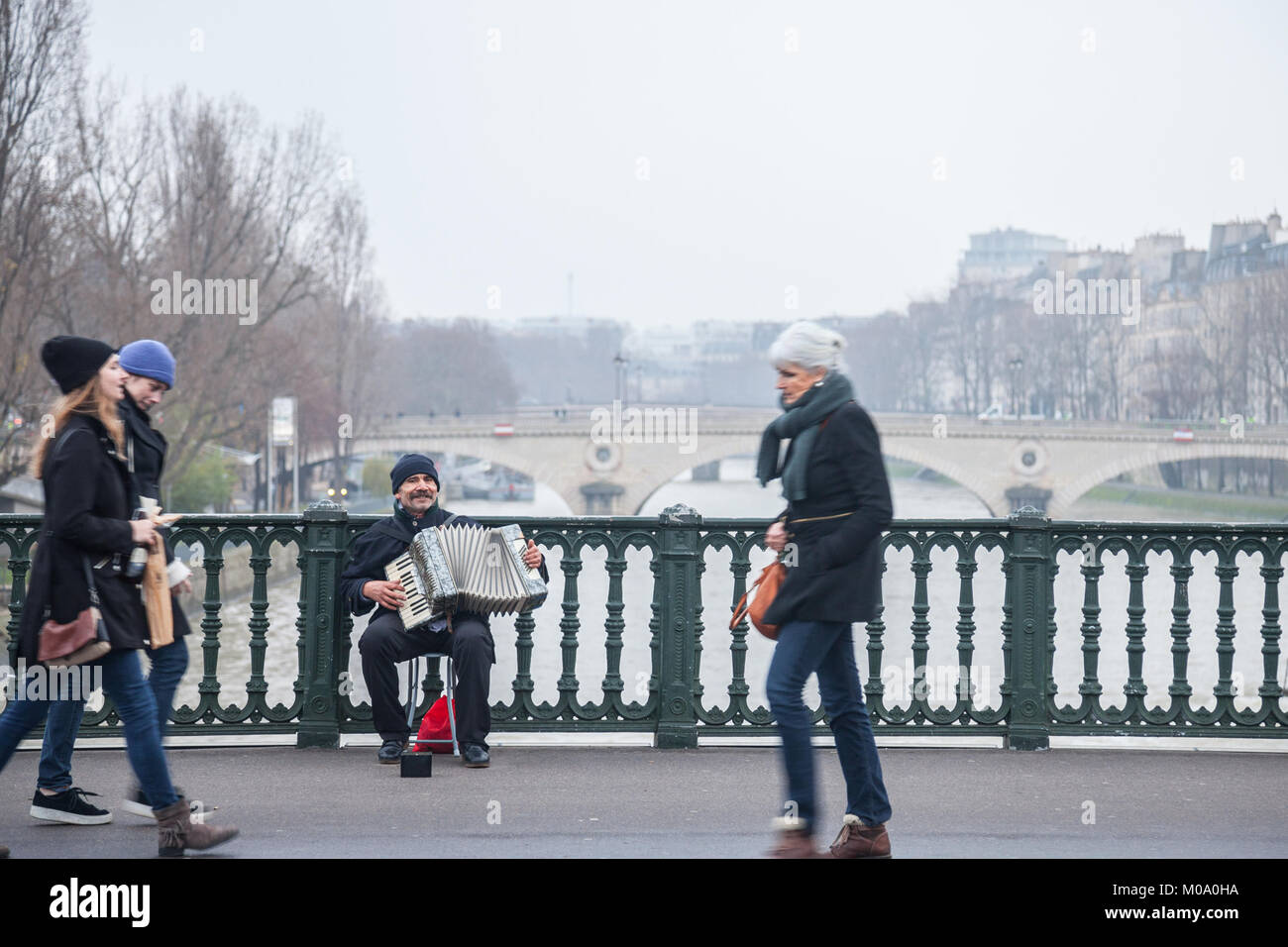 PARIS, FRANCE - 20 décembre 2017 : l'accordéoniste accordéon placage sur le pont d'Arcole à Paris, sur la Seine. La musique d'accordéon est censée Banque D'Images