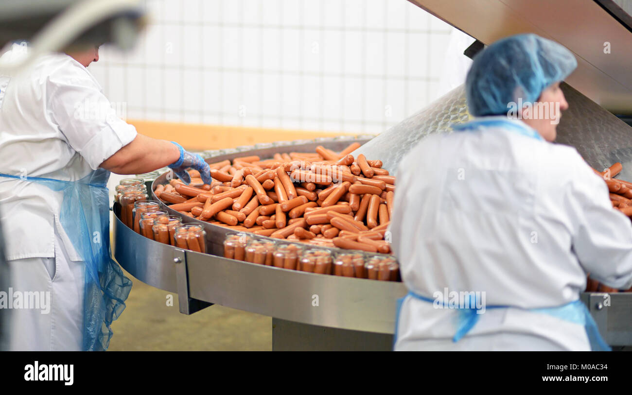 L'industrie alimentaire : les travailleurs dans la production de bratwurst original allemand dans une grande boucherie Banque D'Images