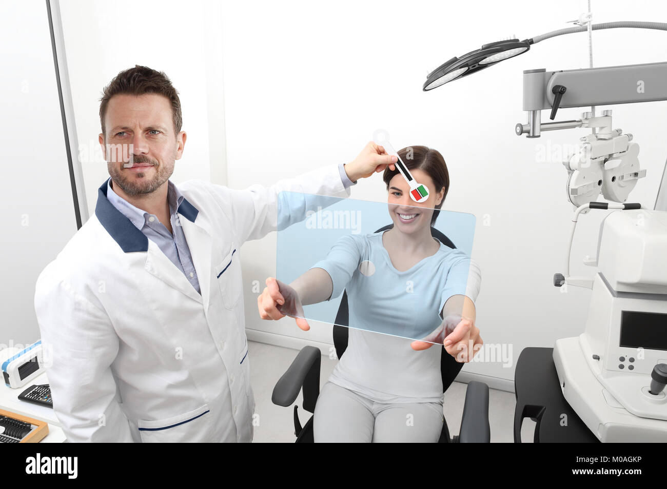 L'examen de la vue, optométriste patient femme pointant vers le trou sur plexiglas, test de dominance oculaire Banque D'Images