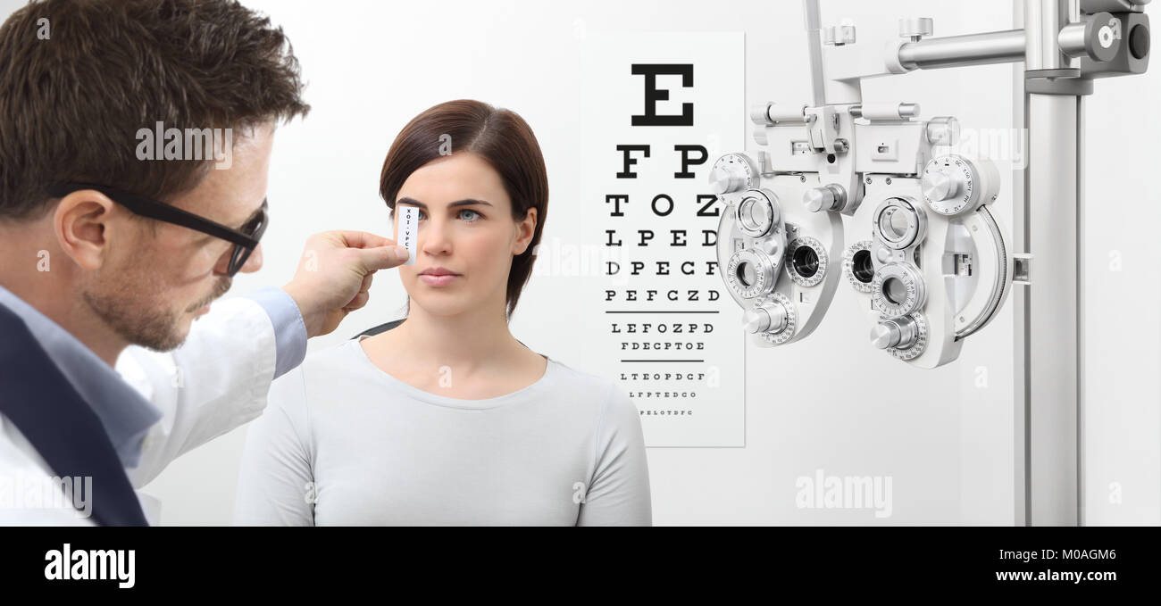 L'examen de la vue, optométriste patient femme pointant sur l'organigramme, les yeux essai examen Banque D'Images
