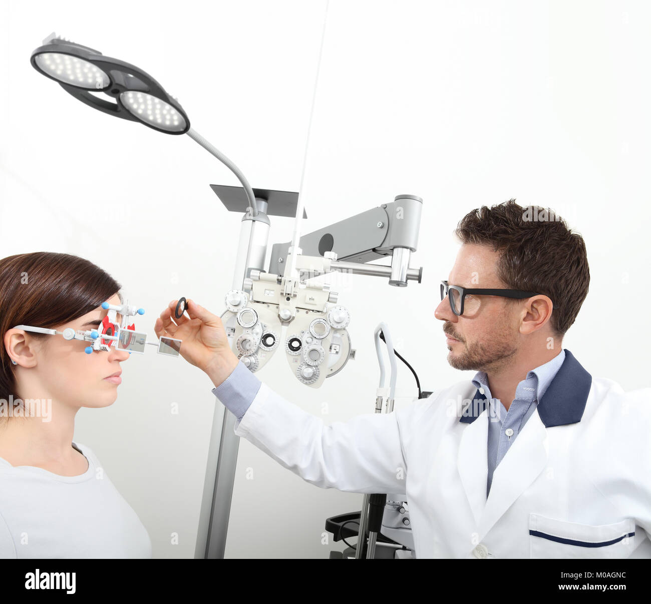 Optométriste avec châssis d'essai l'examen de la vue patient femme au bureau de l'opticien isolated on white Banque D'Images