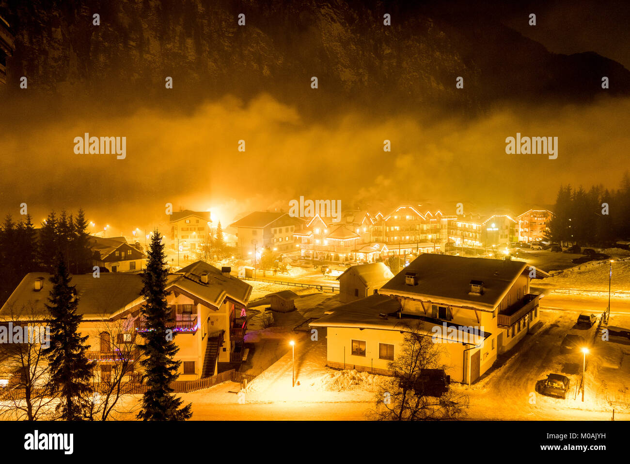 Avis de Campitello avec cloud de faible altitude, et de la vapeur et la fumée des cheminées des chalets. Montagne dans l'arrière-plan. Banque D'Images